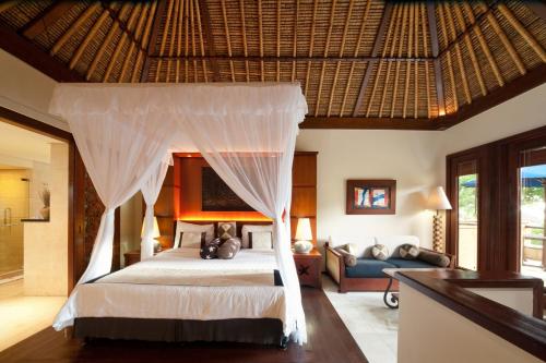 a bedroom with a bed with a mosquito net at Pool Villa Merumatta Senggigi in Senggigi