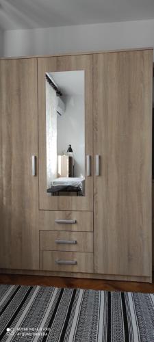 a large wooden cabinet with a mirror in a room at TP Apartman 1 in Križevci