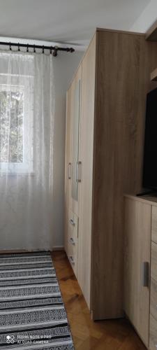 a room with a cabinet and a television and a rug at TP Apartman 1 in Križevci