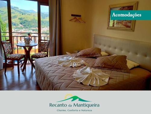1 dormitorio con cama, mesa y balcón en Pousada Recanto da Mantiqueira en Passa Quatro