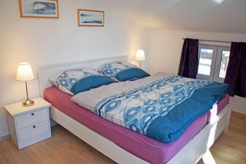 a bedroom with a bed with blue and white sheets at Ferienhaus zum Boddenstrand mit Ka in Groß Zicker