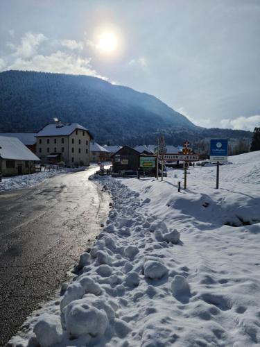 a street covered in snow with the sun in the background at Hôtel du Soleil in Aillon-le-Jeune