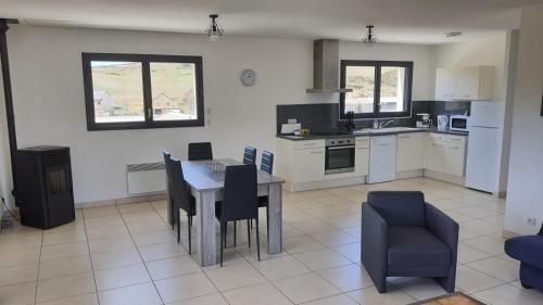uma cozinha com mesa e cadeiras num quarto em Appartement tout confort au milieu de la Margeride em Châteauneuf-de-Randon