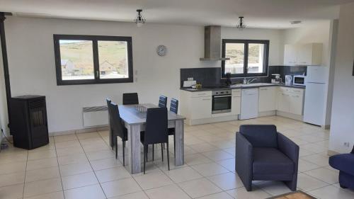 a kitchen with a table and chairs in a room at Appartement tout confort au milieu de la Margeride in Châteauneuf-de-Randon