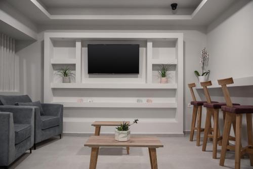 a living room with a tv on a wall at Morum City Hotel Chania in Chania Town