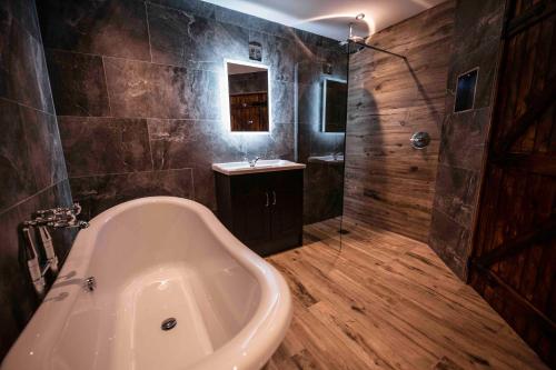 a large bathroom with a tub and a sink at South Causey Inn in Stanley