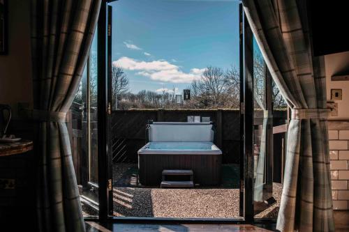 une porte en verre ouverte avec une baignoire dans la cour dans l'établissement South Causey Inn, à Stanley