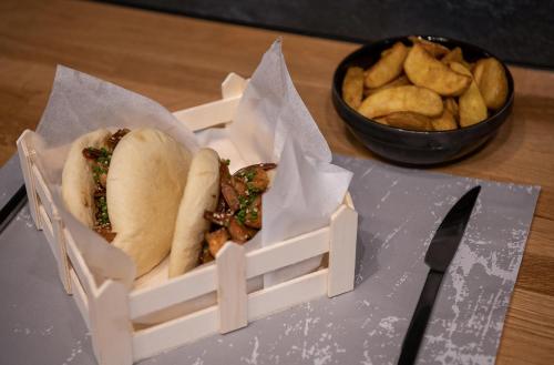 two sandwiches and french fries in a box with a knife at Morum City Hotel Chania in Chania Town