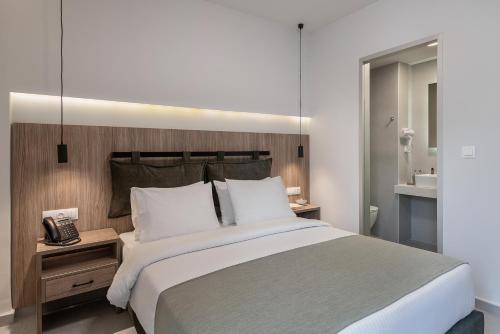 a bedroom with a large bed and a telephone at Morum City Hotel Chania in Chania Town