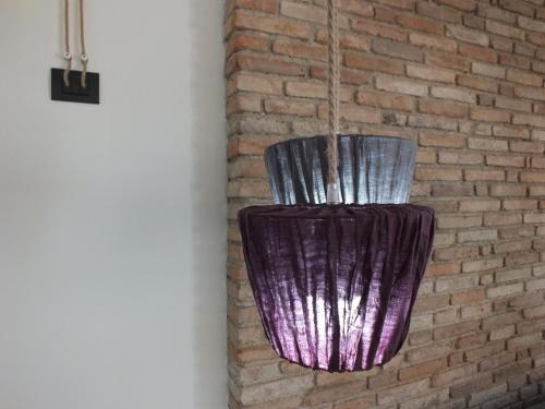 a purple vase hanging on a brick wall at Rocca d'Anfo B&B-Apartments Lake View in Rocca dʼAnfo