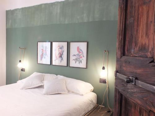 a bedroom with four pictures on the wall and a bed at Rocca d'Anfo B&B-Apartments Lake View in Rocca dʼAnfo