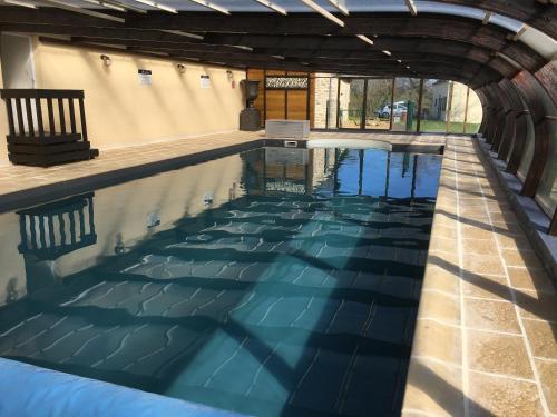 an indoor swimming pool with blue water at Gites de Kermoel, Île de Sein in Kernascléden