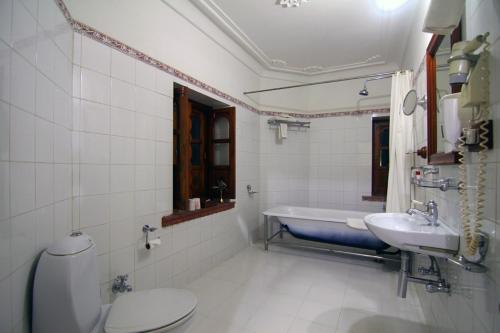 La salle de bains est pourvue de toilettes, d'un lavabo et d'une baignoire. dans l'établissement Jagat Palace, à Pushkar