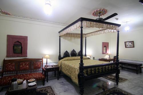 a bedroom with a canopy bed and two tables and a bed sidx sidx at Jagat Palace in Pushkar