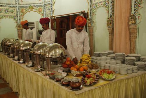 a group of men standing around a table with food at Jagat Palace in Pushkar
