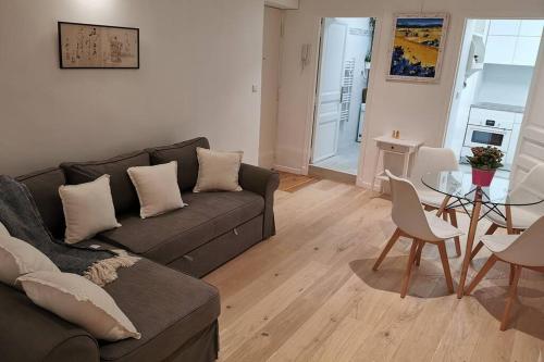 un salon avec un canapé et une table dans l'établissement 3min RER - Hypter Center St Germain En Laye - Wei&Pei Apartment, à Saint-Germain-en-Laye