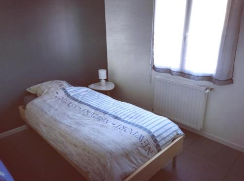 ein kleines Bett in einem Schlafzimmer mit Fenster in der Unterkunft Maison neuve 66m2 Biscarrosse in Biscarrosse