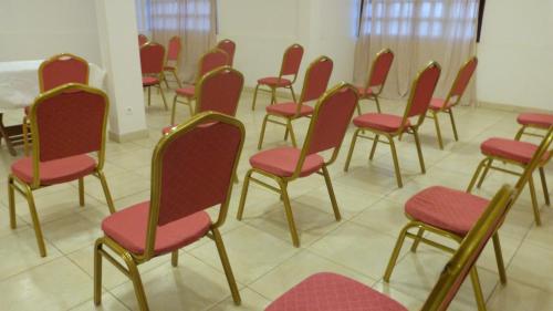 a row of chairs with red seats in a room at Hotel Madou Grand Bassam in Grand-Bassam