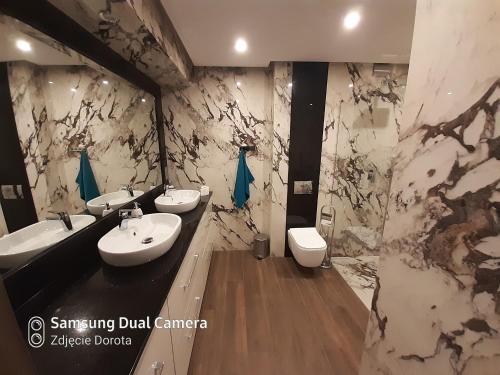 a bathroom with three sinks and two toilets at Apartament Mszana Dolna in Mszana Dolna