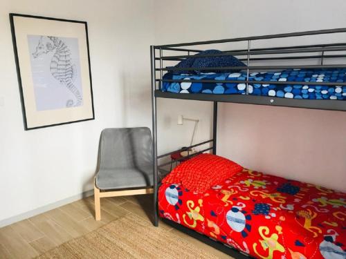 a bedroom with a bunk bed and a chair at Casa da Ilha in Madalena