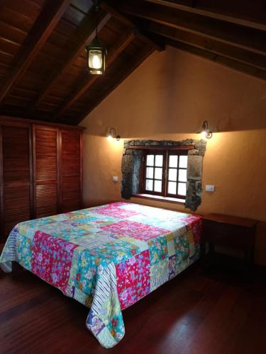 um quarto com uma cama com uma colcha colorida em El pajar de Inés em La Orotava