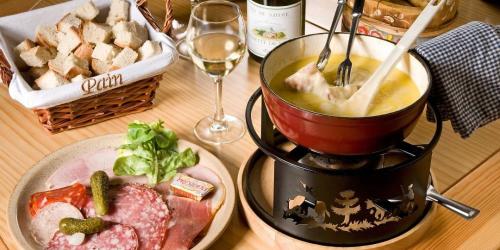 a table with a blender and a plate of food at Hôtel du Soleil in Aillon-le-Jeune