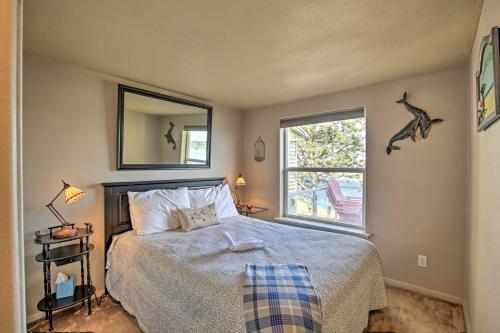 ヴァルドポートにあるWaldport Beach House with Loft, Grill and Ocean Views!のベッドと鏡と窓のある寝室
