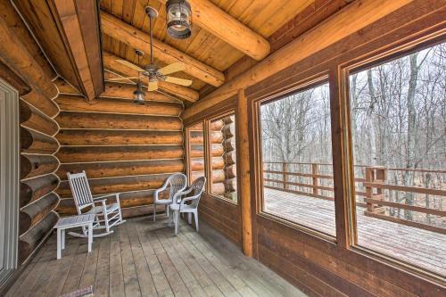 a log cabin porch with chairs and windows at Lodge on 104 Acres with Fire Pit in Boyne City in Petoskey