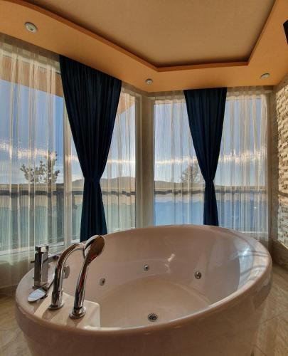 a large bath tub in a bathroom with windows at Safi in Dospat