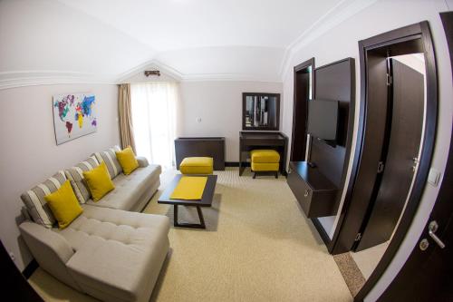 a living room with a couch and a tv at Hotel Swiss Holiday in Budva