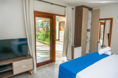 a bedroom with a bed and a flat screen tv at Villa Zen Hotel in Camocim