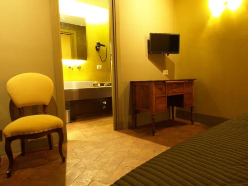 a bedroom with a bed and a chair and a television at Le Stanze Del Duomo in Anagni