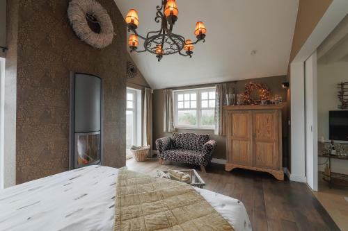 a bedroom with a large bed and a chandelier at Le Nid Douillet in Theux