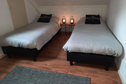 two twin beds in a room with two lights on them at Gezellige vakantiewoning met sauna in Ewijk bij Nijmegen - recreational only no workers in Ewijk