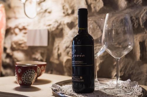 a bottle of wine sitting next to a wine glass at Agriturismo Poggio Il Castellare in Montalcino