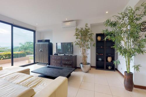 uma sala de estar com vasos de plantas e uma televisão em Nativa A14 em Jacó