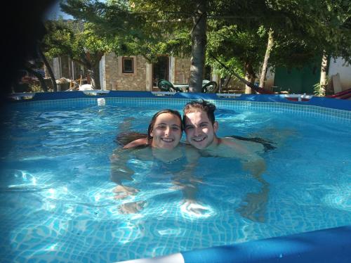 un hombre y una mujer nadando en una piscina en Casa Rural Chulilla, en Villarroya de los Pinares