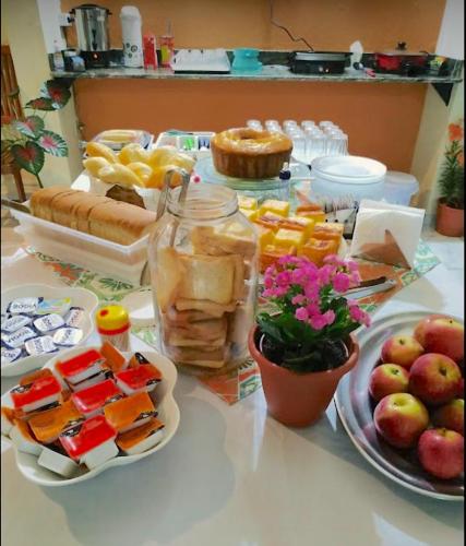 uma mesa coberta com um buffet de alimentos e frutas em VELINN Pousada Praia do Perequê em Ilhabela