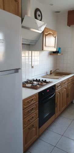 une cuisine avec une cuisinière et un réfrigérateur dans l'établissement L'Océnoa, à Mimizan-Plage