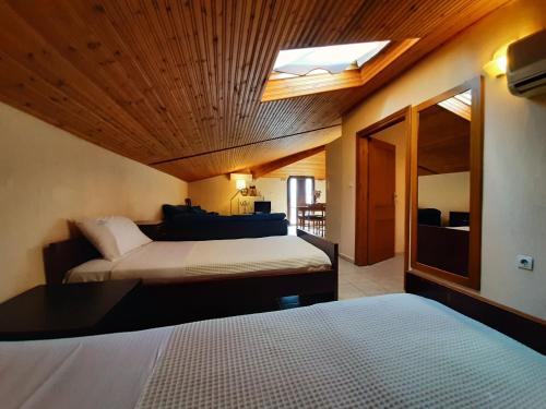 a bedroom with two beds and a skylight at Hotel Flesvos in Pefkochori
