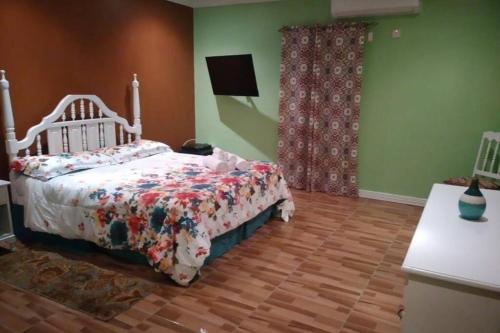um quarto com uma cama com um edredão em Ocho Rios Hideaway em Ocho Rios