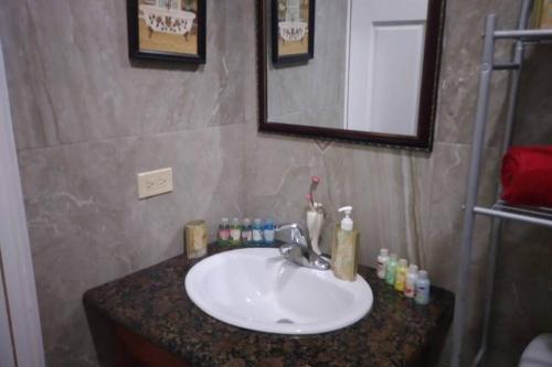 a bathroom with a sink and a mirror and a counter at Ocho Rios Hideaway in Ocho Rios