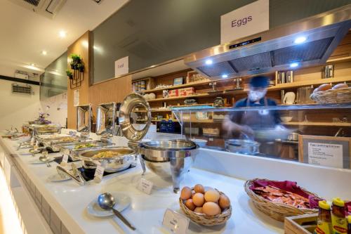 a man behind a counter in a kitchen preparing food at PLAAI Prime Hotel Rayong SHA Extra Plus in Rayong