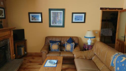 a living room with a leather couch and a table at Artesano I y III in Navarredonda de Gredos