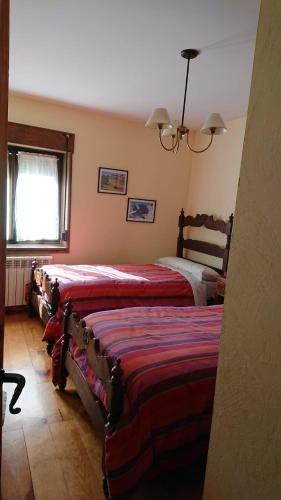 a bedroom with two beds and a window at Artesano I y III in Navarredonda de Gredos