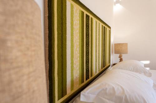 a bedroom with a green and white striped wall at Cerro da Campaniça in Santiago do Cacém