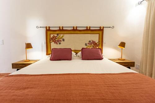 a bedroom with a large bed with two lamps at Cerro da Campaniça in Santiago do Cacém
