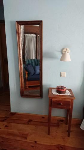 a mirror and a table with a chair in a room at Artesano I y III in Navarredonda de Gredos