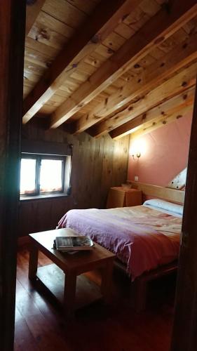 a bedroom with a bed and a table in a room at Artesano I y III in Navarredonda de Gredos