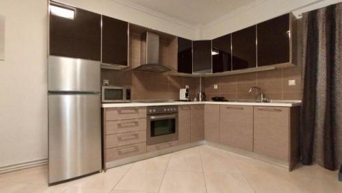 a kitchen with stainless steel appliances and brown cabinets at EPaN Luxury Apartments in Thessaloniki